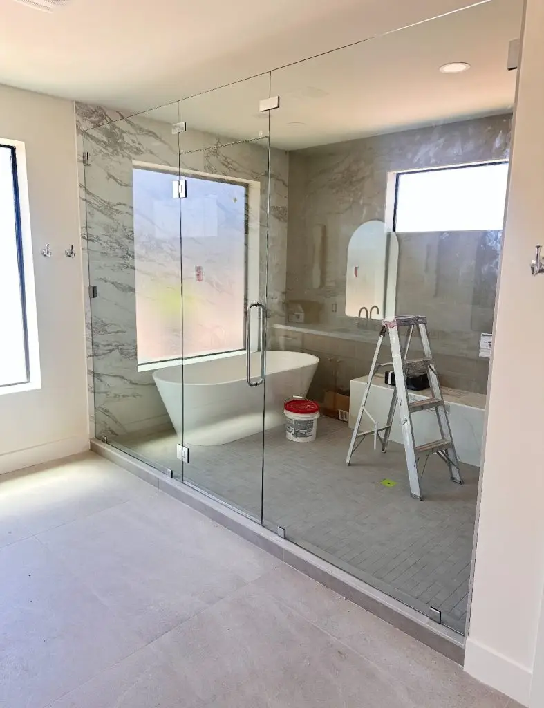 Luxury bathroom remodel in Scottsdale, AZ featuring custom tile, free standing tub, and walk-in shower with big windows