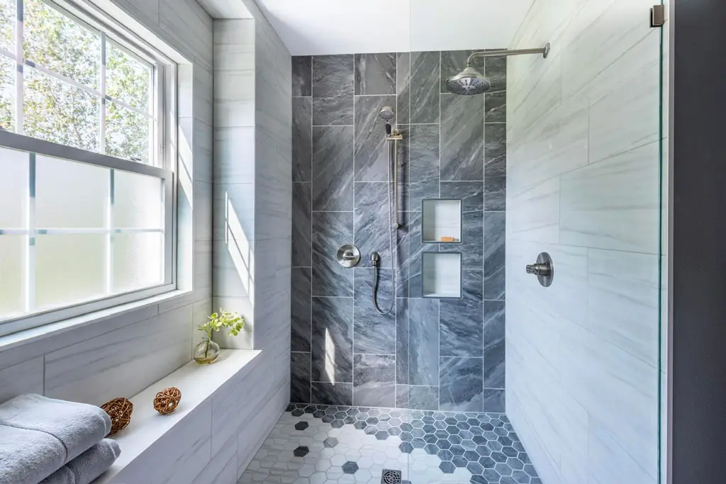Gorgeous interior renovation bathroom remodeling job by General Contractor Drill Renovations. Trendy stone and mable tile with bright window in Scottsdale luxury home.
