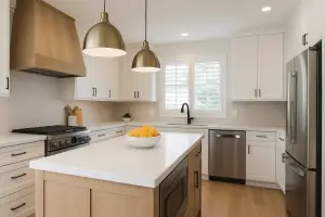 Spacious modern kitchen with natural light, white cabinets, quartz countertops, light wood flooring, and a large center island with barstools.