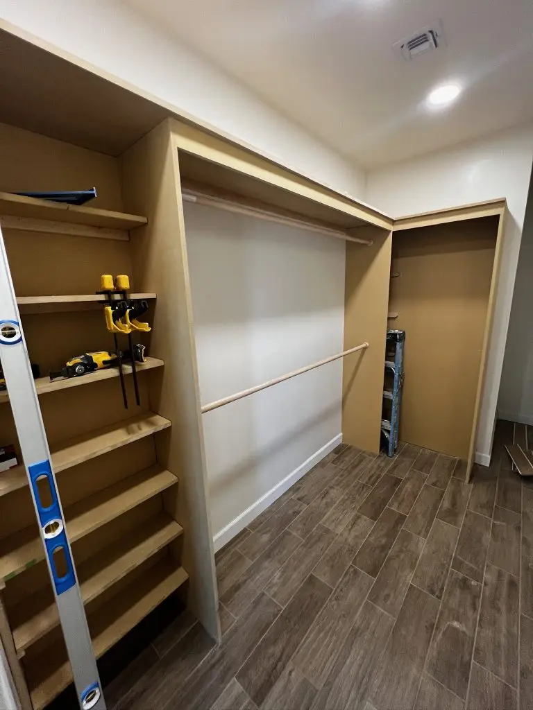Custom closet renovation in Phoenix featuring built-in shelving, double hanging rods, and warm wood finishes by Drill Renovations.